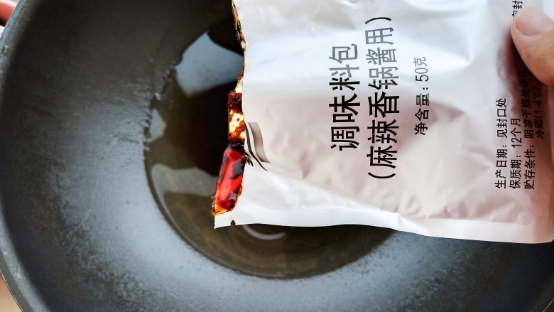 馋哭小孩的麻辣香锅,锅中加入30毫升左右的食用油，加入两包家乐麻辣香锅料。