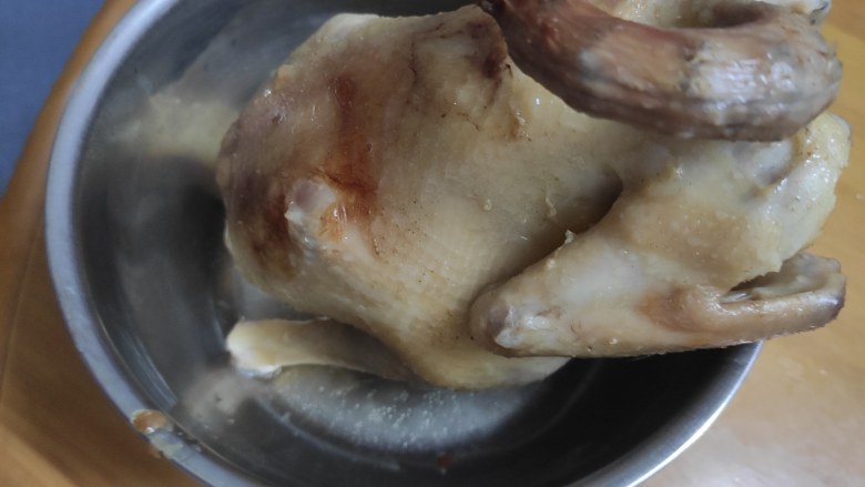 电饭煲盐焗鸡,把三分之一的鸡汁抹到鸡身上