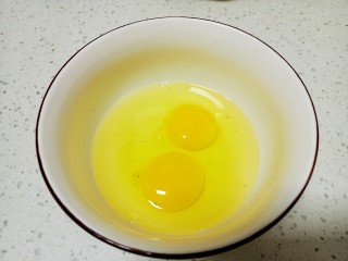 蒲公英蒸饭,鸡蛋打入碗中 