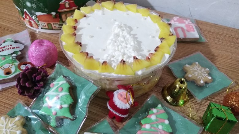 圣诞树蛋糕,圣诞树挤上小花，蛋糕周围铺水果，摆些圣诞摆件