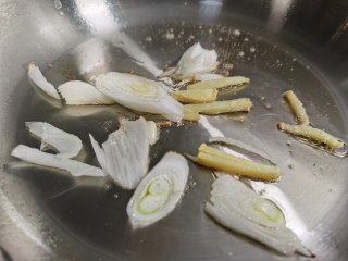 白菜烩小酥肉,锅中加入少许食用油，放入葱姜爆香。