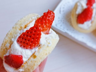 草莓抱抱卷,将蛋糕坯稍微弯曲握起来，放上草莓。