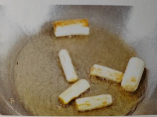 葱烧海参,放入葱白段，用中火炒至微黄，放入海参条炒匀
