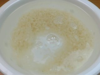 蛋黄养生粥,接下来准备100克的大米，用清水把它清洗干净。