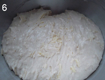 松软的Pizza奶酪面包,第一次发酵后的面团体积有明显增长，有明显发酵的酸味。取出折两次三折，放回容器，盖上保鲜膜，第二次发酵90分钟