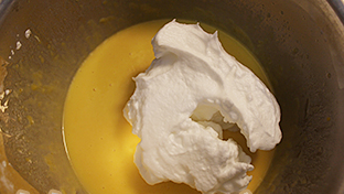 虎皮蛋糕,勺1/3打发好的蛋白放入蛋黄糊中，以重复用刮刀从底部翻起，直面再切入混合物，转着容器将蛋白蛋黄混合均匀（速度最好能快些，防止消泡）