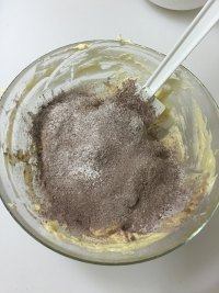 可可杏仁冻曲奇,将低筋面粉和可可粉混合筛入黄油糊中。
