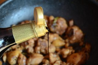 香菇焖鸡腿,炒干鸡肉的水分，呈金黄色，淋入老抽翻炒上色