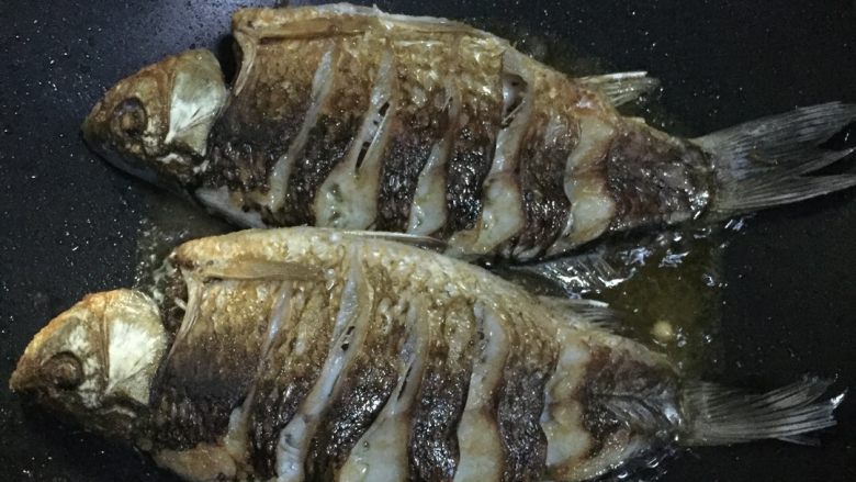 香辣豆豉鲫鱼,锅里放适量油，油烧热后放鱼入锅煎