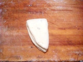 香甜核桃豆沙卷,在纵向折叠，用小刀在面团中间划一大口子