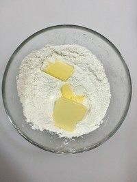 黑芝麻软曲奇,将低筋面粉、细砂糖、盐、泡打粉混合称量。无盐黄油切小块（无需软化），放入混合粉中。