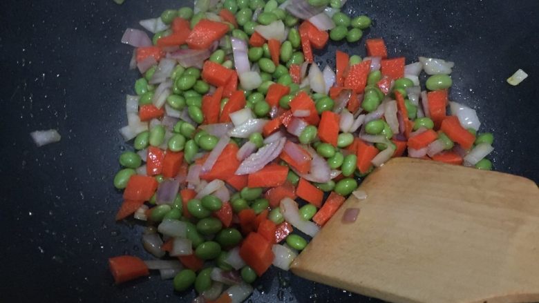 好好ci牌焖饭,热锅加油。放入洋葱、胡萝卜、青豆。将洋葱炒香即可。
