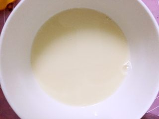 芒果慕斯杯,牛奶加热到六七十度，将泡软的吉利丁片放入融化，搅拌均匀。