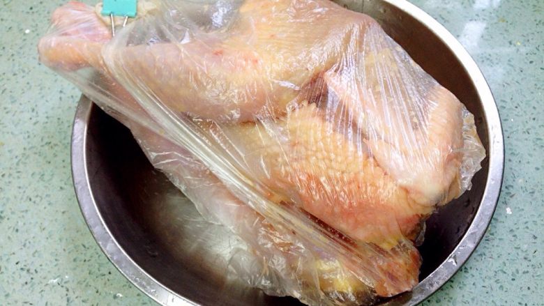地方菜 手撕盐焗鸡（烤箱版）,把盐焗鸡粉均匀地涂抹在鸡身里里外外，按摩片刻，在鸡肚子塞入姜片，用保鲜袋装好密封，放冰箱过夜。