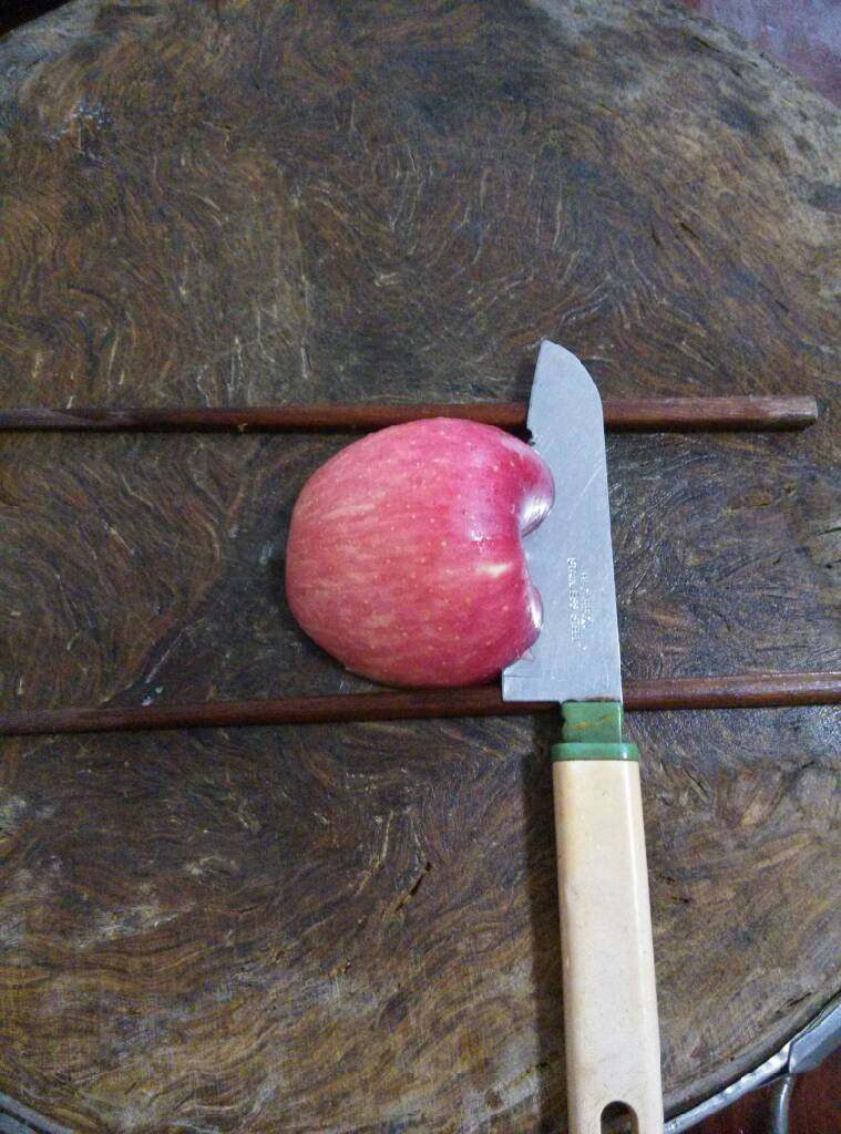创意苹果，火龙果,取另一半苹果同样放在筷子中间横切出一片苹果片