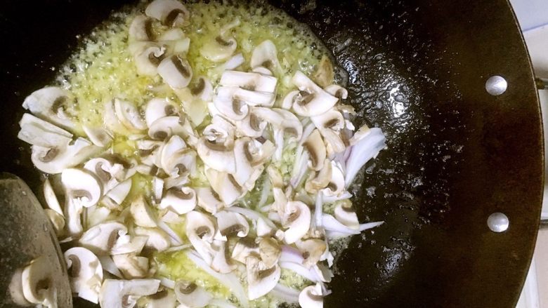 鲜虾蘑菇螺旋面,下蘑菇和洋葱。继续翻炒。多炒一会。