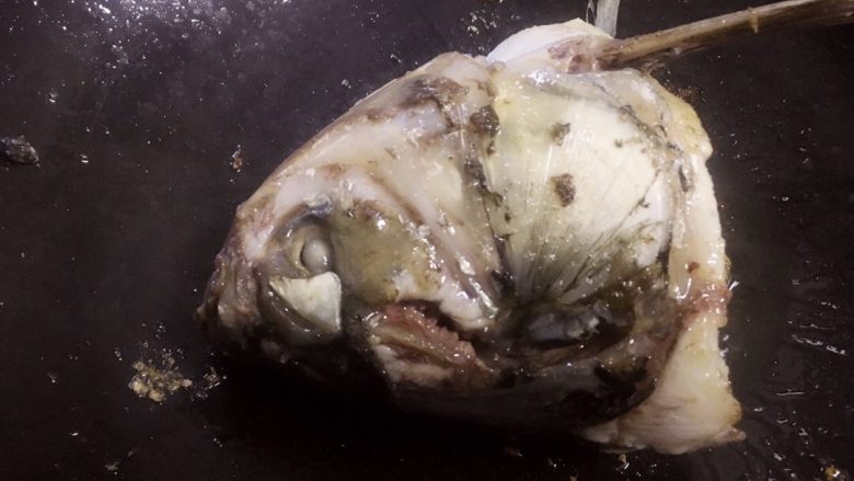 鱼头豆腐汤,锅底用姜片摩擦后，倒入适量油（猪油最佳）。将鱼头两面煎香。