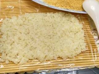 糯米团,准备一个包寿司的竹帘，裹上一层保鲜膜，把蒸熟的糯米平铺在竹帘上。