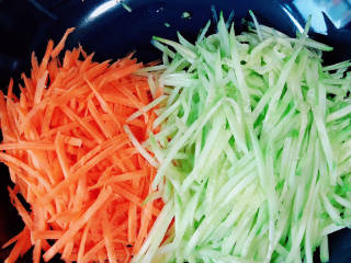 凉拌粉丝黄瓜,黄瓜、胡萝卜叉丝儿放入盘中。