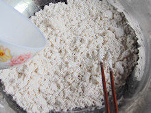 手工白雪馒头,把酵母水缓缓的倒入面粉中，边加边用筷子搅拌成絮状