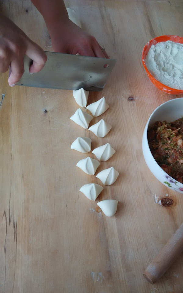 饺子,取出一半面团揉条，转动面条切块。如果是自己一人在包饺子，取出的面不要太多，面团怕干皮