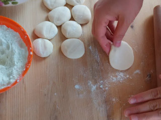 饺子,撒干面粉把切好的块按扁，开始擀面皮