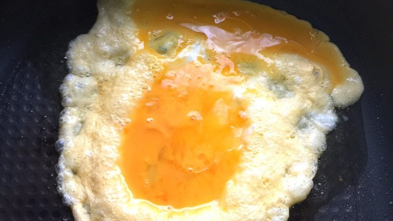 野韭菜炒鸡蛋#春意绿#,锅中倒入适量核桃油，烧热后倒入鸡蛋液煎炸片刻。