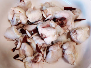 姜葱冬菇蒸滑鸡,锅中烧开水，加入料酒，下入鸡翅根，煮去血水祛除腥味，捞出洗净，放入大碗中。
