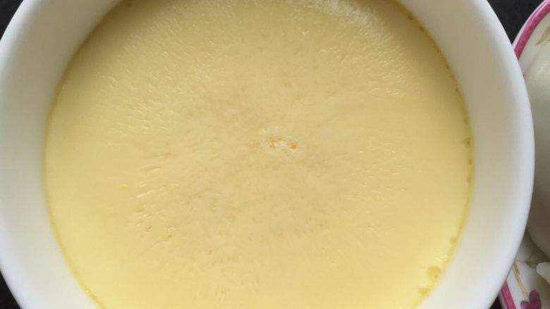嫩滑水蒸蛋,盖上保鲜膜，用牙签在保鲜膜上戳几个小洞，放进煮蛋器蒸，大概12～15分钟