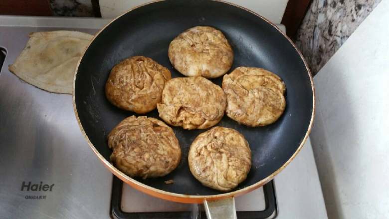 麻酱芝麻烧饼,将面卷分成均匀的小分，摁成烧饼胚，放在平底锅，放在火上稍微加热。