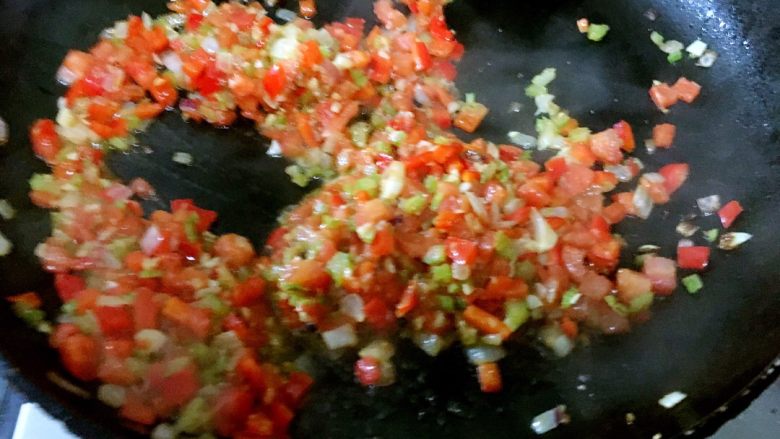 西班牙海鲜饭,炒香了蒜茸和洋葱后，加入番茄，转中火炒出番茄汁