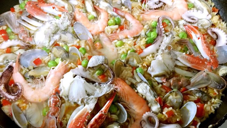 西班牙海鲜饭,小火大约20-30分钟看米饭成熟度，米饭好了就把准备好的海鲜摆好放入锅中，把海鲜往米里按压，继续闷，让米饭的味道也进入海鲜