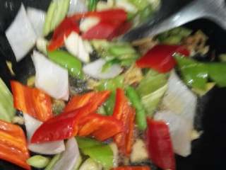 家常小炒牛肉,倒入青红椒，洋葱翻炒均匀，加入适量盐。