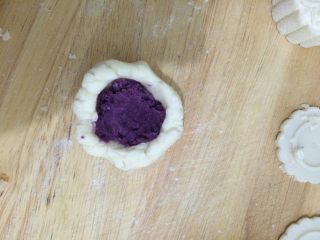 山药紫薯糕,取一块山药泥，捏成小碗的形状，里面放入紫薯泥，搓成圆形。