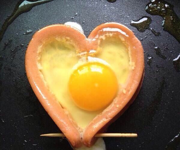 爱心煎蛋,锅烧热加油，放入火腿肠，鸡蛋打进心形火腿肠里