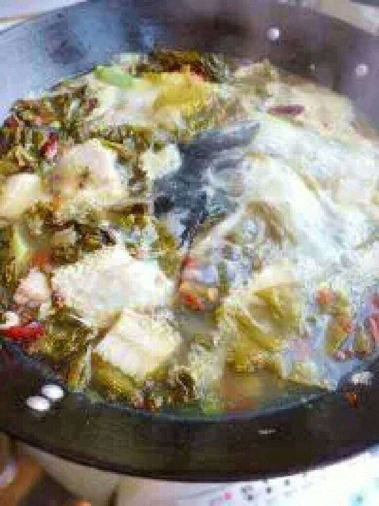 江湖酸菜鱼,将鱼头及鱼骨下入，大火烧开，撇去浮沫，煮约10分钟，加入鸡精。