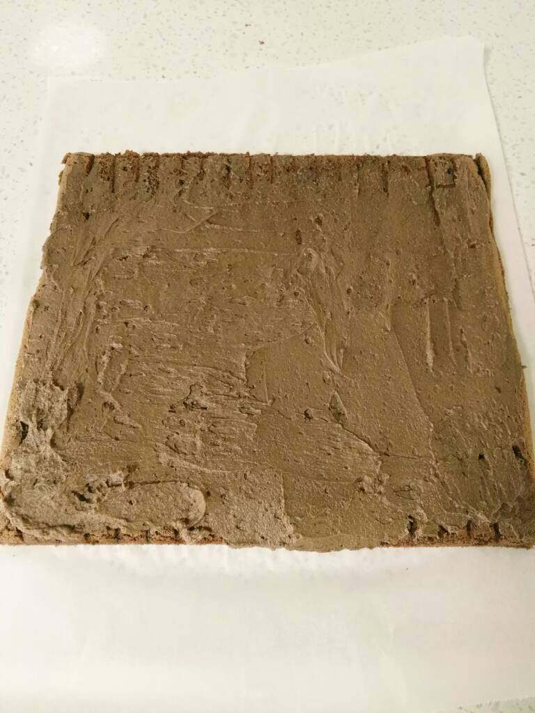 波点巧克力蛋糕卷,把巧克力奶油馅抹在蛋糕上，开始卷，也可以用擀面杖卷。