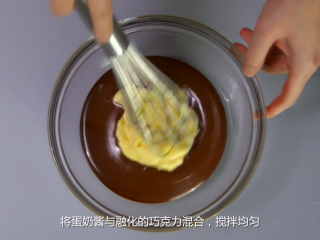 橙香巧克力舒芙蕾,将蛋奶酱与融化的巧克力混合，搅拌均匀