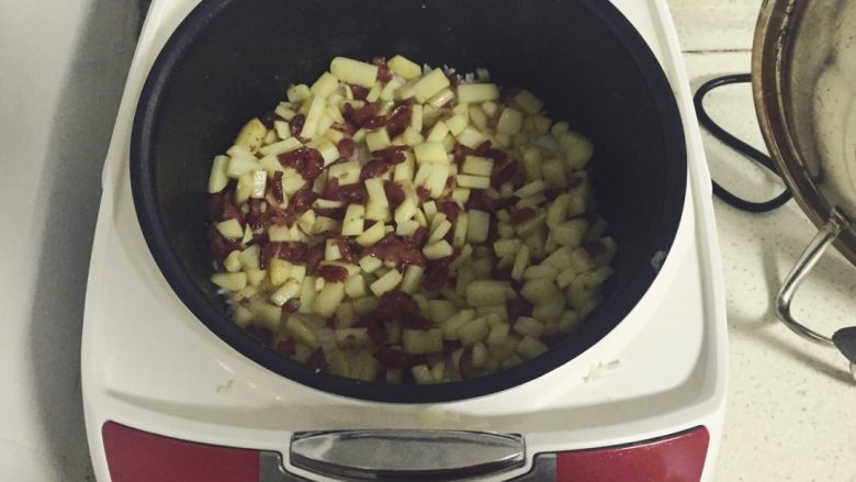 土豆香肠丁焖饭,将刚才烧好的土豆香肠倒入即将煮熟的饭中，盖上盖子继续焖…直到饭滴滴响起好了再打开～