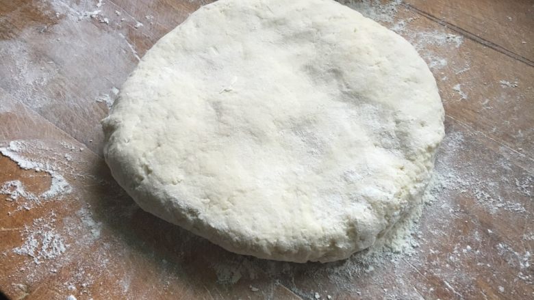 烙饼,将面团放在展板上，加面粉用擀面杖擀开。