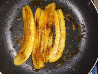 焦糖朗姆香蕉,把香蕉放进锅里，两面煎成金黄色，再把腌制好的白葡萄干、黑葡萄干倒进锅里，加入少许的朗姆酒，最后收汁。