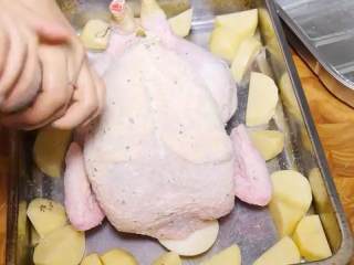 百里香烤鸡,把鸡放在洋葱的上面，在表面均匀的撒上盐和黑胡椒