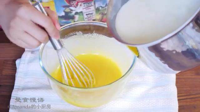 草莓布丁杯,把装了蛋黄的碗放在布上固定，把牛奶混合物边倒边搅拌