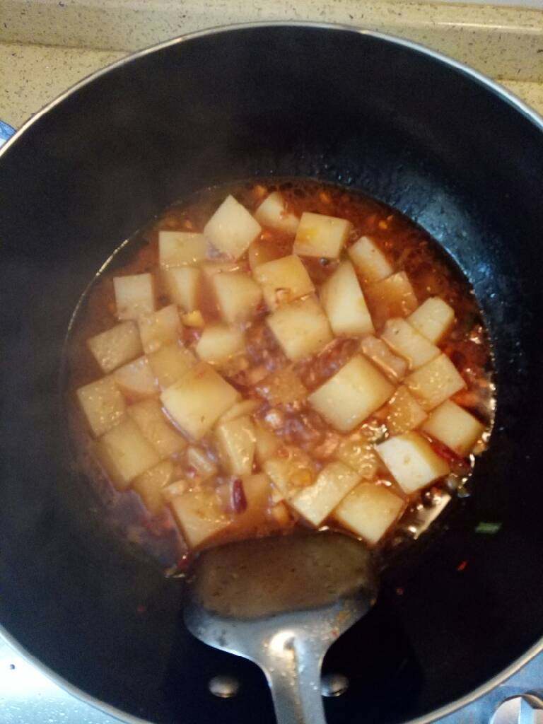 麻辣米豆腐,锅里汤汁烧开后，开小火，放入花椒面，葱花，翻炒几下，关火，加入鸡精翻炒，即可出锅