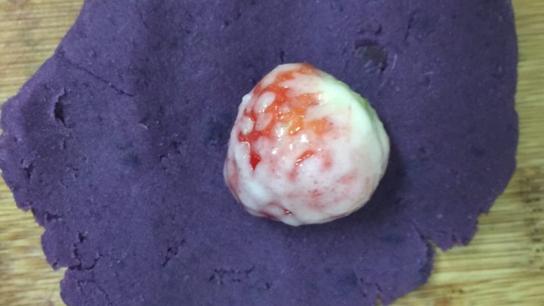 草莓椰蓉紫薯球,然后把紫薯压成紫薯泥，再压成饼的形状，把草莓放进去，搓成球状。