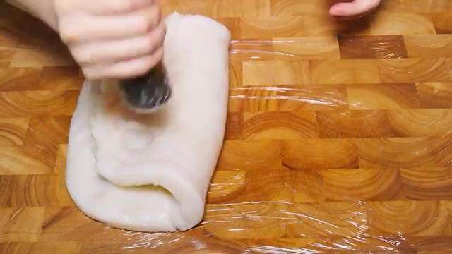 自制水磨年糕,在米粉团上抹上少许植物油，把石杵用保鲜膜包起来捣年糕