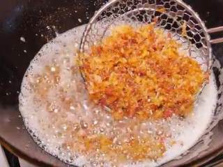 自制XO瑶柱酱,最后倒入火腿碎，继续炸上3-5分钟，直至都脱水呈金黄色，捞出放入另一锅