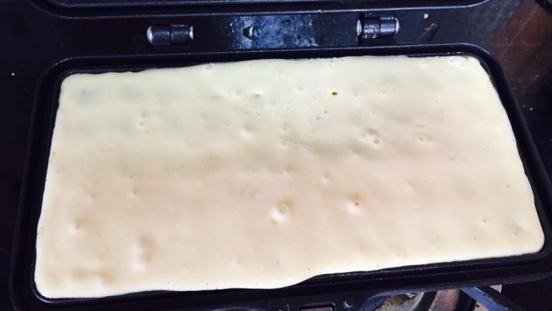 自制美味华夫饼,准备一小块黄油融化，刷在华夫模具上，倒入面糊，小火7分钟煎左右即熟.注意过程勤翻面.
