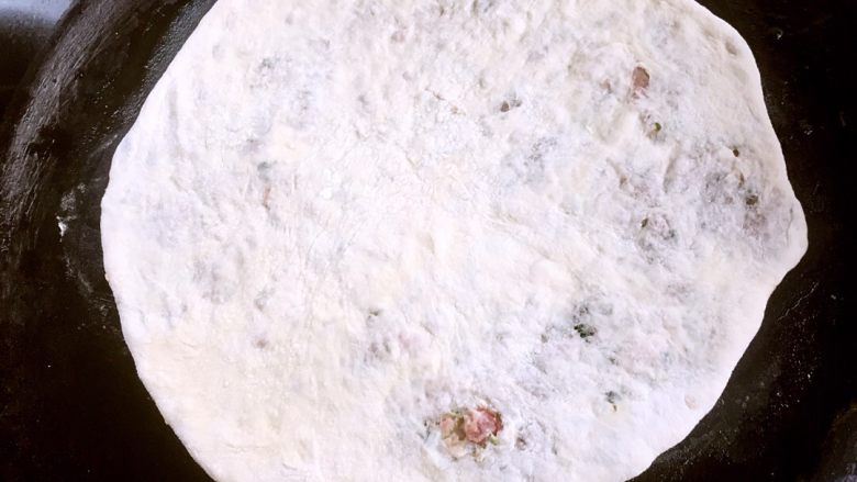 梅干菜猪肉麦饼,醒好的陷饼用擀面杖擀成薄饼，平底锅刷油，将薄饼摊在锅上，撒几滴水盖锅盖小火焖一两分钟。