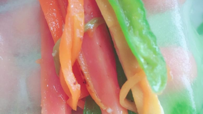 夏日里的红配绿,用筷子将做好的食材摆好在黄瓜皮上，卷起